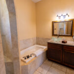 Ensuite bathroom with jetted tub and separate walk-in shower in La Grotta Messina Inn Wimberley Texas Hill Country Hotel